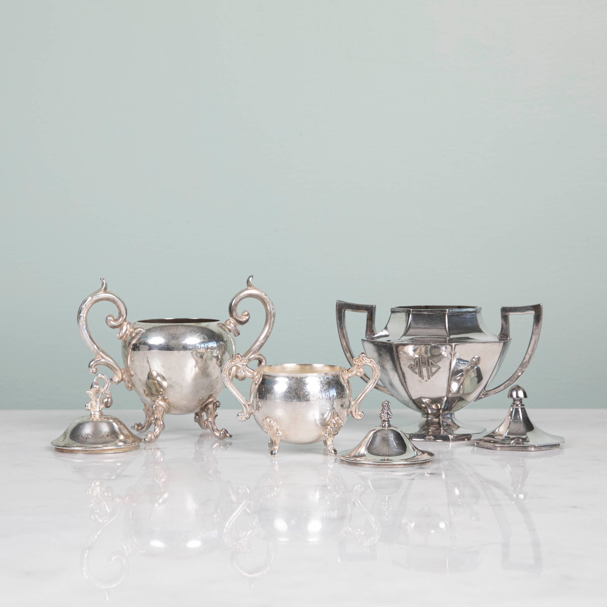 A Hester &amp; Cook vintage silver-plate sugar bowl on a pink tablecloth.