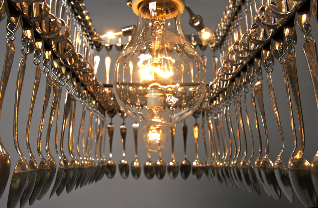 Double Tier Rectangular Spoondelier with multiple reflective pendants against a gray background by Hester &amp; Cook.