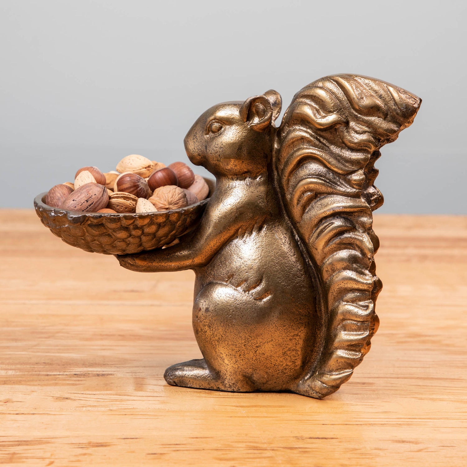 A bronze Accent Decor squirrel holding a bowl of moss.
