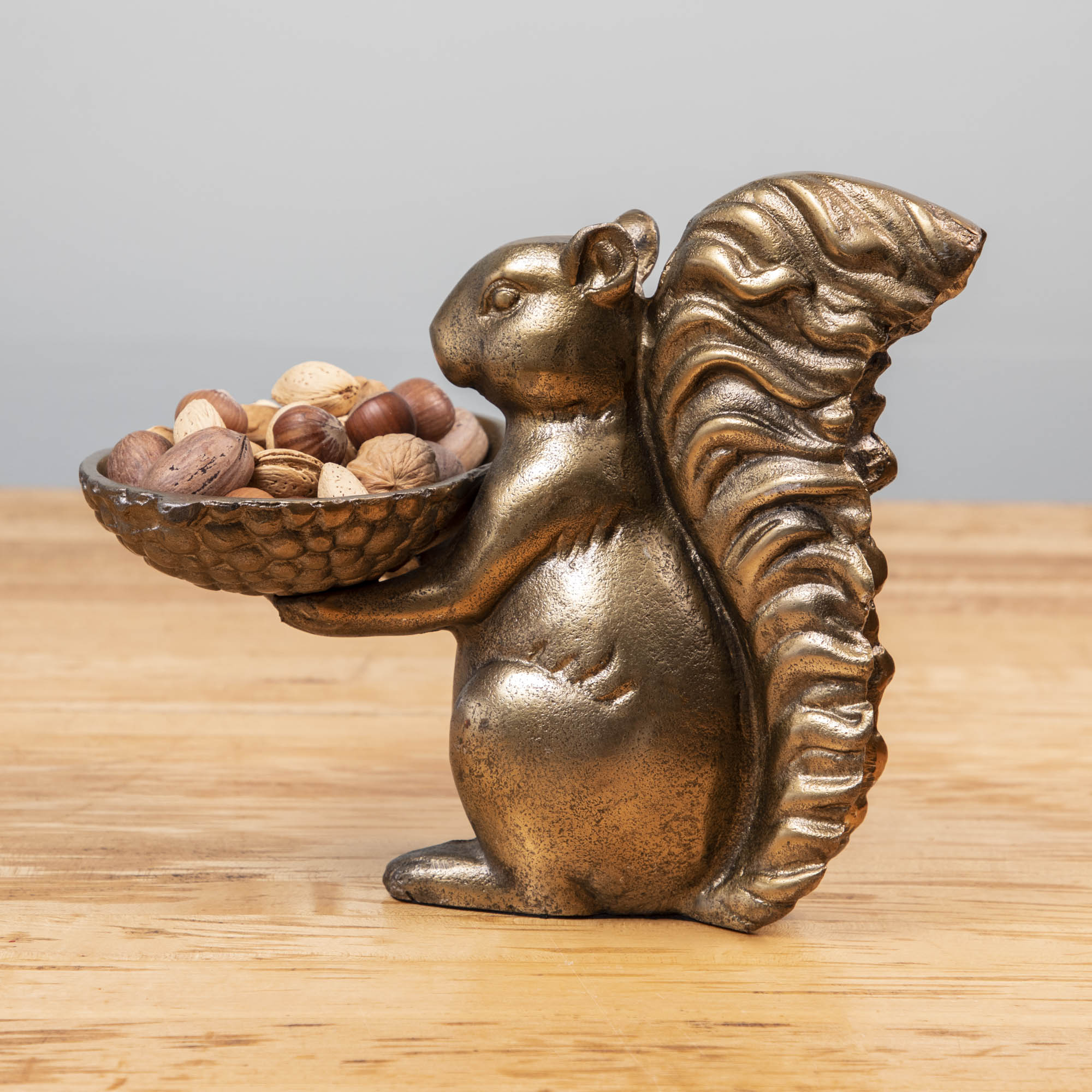 A bronze Accent Decor squirrel holding a bowl of moss.