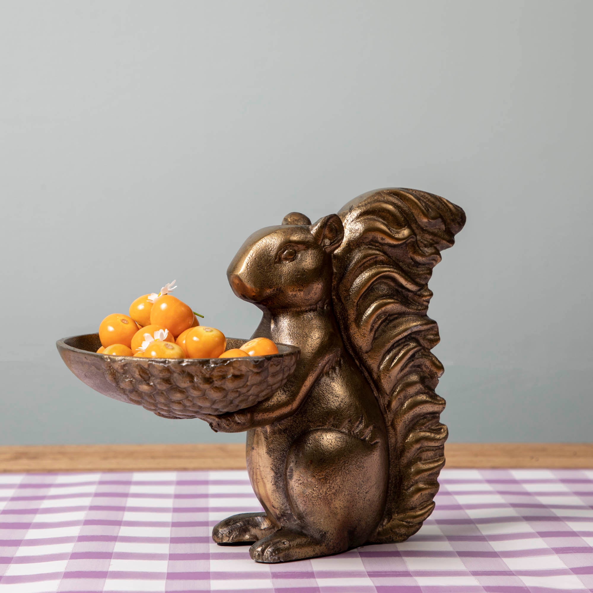 A bronze Accent Decor squirrel holding a bowl of moss.