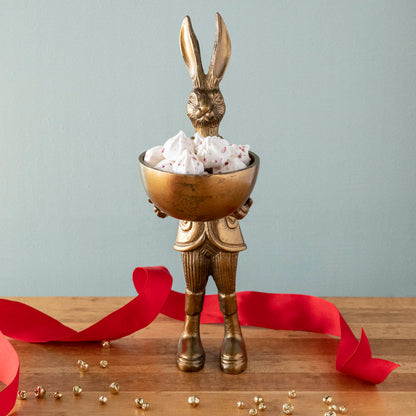 A well-dressed standing Hare Dishstand by Accent Decor holding a round dish of candy on a table.