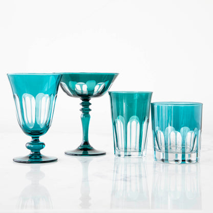 Set of four bespoke Rialto Millicent (Dark Green) glasses by SIR/MADAM on a reflective surface against a white background.