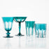 Set of four bespoke Rialto Millicent (Dark Green) glasses by SIR/MADAM on a reflective surface against a white background.